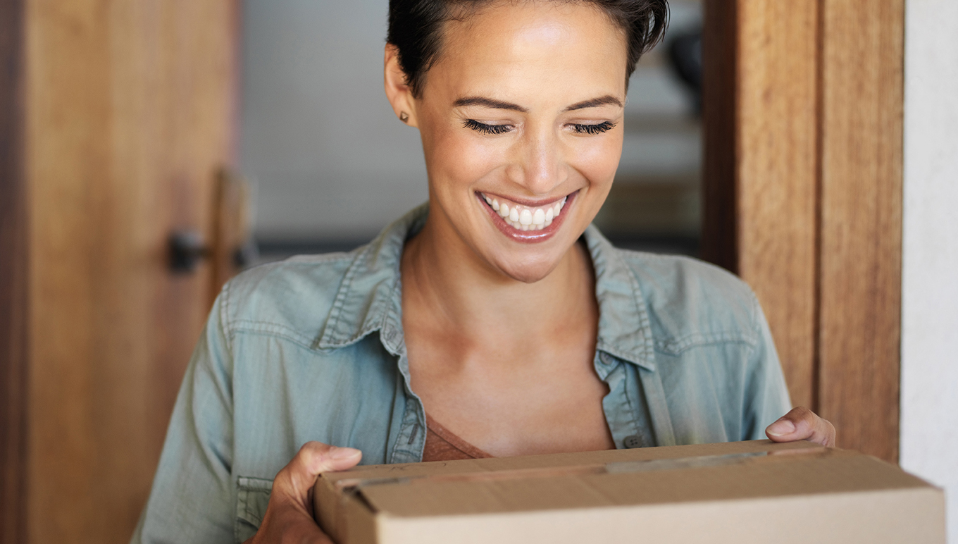Femme heureuse recevant un colis à domicile
